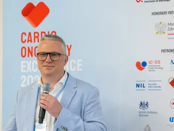 Mężczyzna w jasnej marynarce z mikrofonem, obok logotypy i napisy związane z cardio-onkologią.