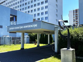 Centrum Edukacyjno-Konferencyjne z rzeźbą na pierwszym planie, budynek w tle.