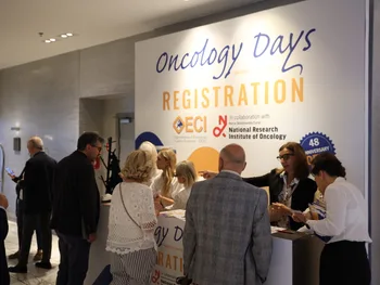 Ludzie przy stoisku rejestracyjnym na wydarzeniu Oncology Days.