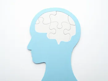 Sylwetka głowy z puzzlami w miejscu mózgu na białym tle