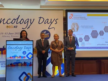 Cztery osoby stoją na scenie podczas konferencji Oncology Days w Atenach, obok ekranu z prezentacją.