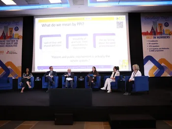 Sześć osób siedzi na scenie podczas konferencji. Na ekranie wyświetlona prezentacja o zaangażowaniu pacjentów.