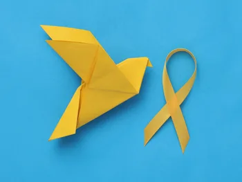 Żółty ptak origami i żółta wstążka na niebieskim tle