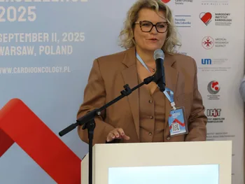 Kobieta w okularach przemawia przy mównicy na konferencji Cardio-Oncology Excellence 2025 w Warszawie.