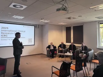 Osoby siedzące na krzesłach w sali konferencyjnej, ekran z napisem „2025 International Clinical Research Conference ICRC”.