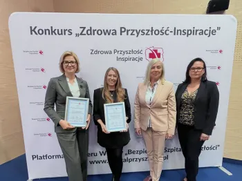 Cztery osoby stoją przed ścianką z napisem „Konkurs Zdrowa Przyszłość-Inspiracje” trzymając certyfikaty.