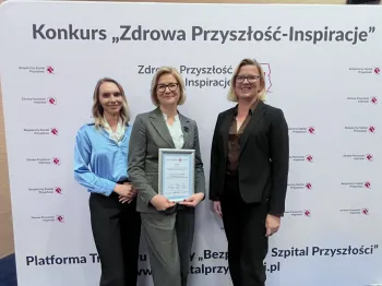 Trzy osoby stoją przed ścianką z napisem „Konkurs Zdrowa Przyszłość-Inspiracje” trzymając dyplom.