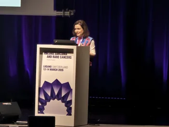 Kobieta przemawia na konferencji, stoi przy mównicy z napisem o rzadkich nowotworach w Lugano.