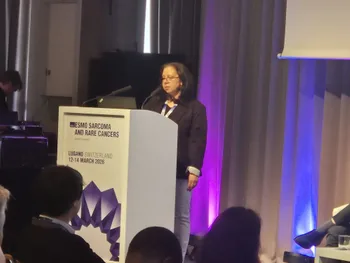 Kobieta w okularach przemawia przy mównicy na konferencji ESMO Sarcoma and Rare Cancers.