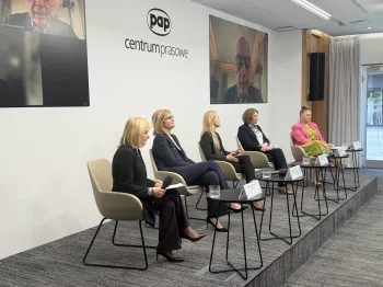 Pięć osób siedzi na krzesłach w sali konferencyjnej PAP, za nimi ekran z osobą na wideokonferencji.