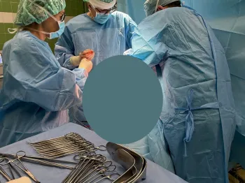 Trzech chirurgów w sali operacyjnej, na stole narzędzia chirurgiczne.