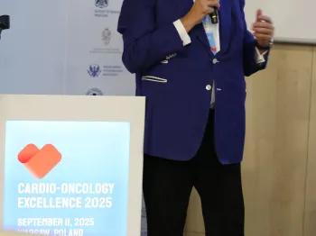 Mężczyzna w niebieskiej marynarce przemawia na konferencji Cardio-Oncology Excellence 2025 w Warszawie.